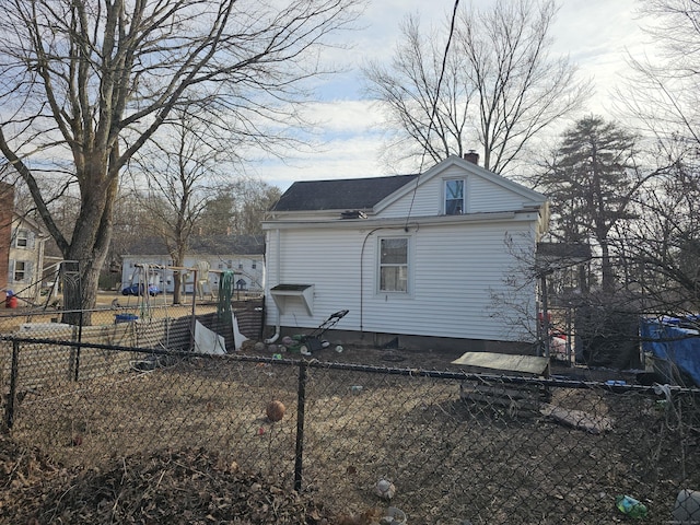 back of property with fence private yard and a chimney