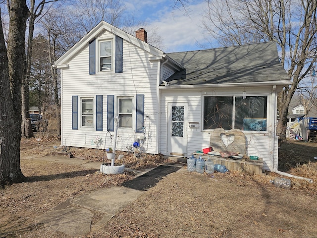 view of front of property with a chimney and roof with shingles