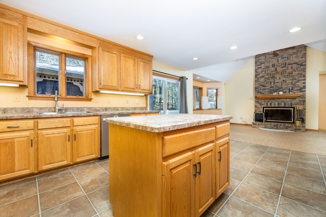 kitchen with a center island, light countertops, vaulted ceiling, stainless steel dishwasher, and a sink