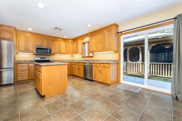 kitchen featuring visible vents, a kitchen island, recessed lighting, a sink, and stainless steel appliances