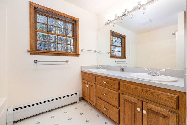 bathroom featuring a sink, baseboard heating, walk in shower, and double vanity