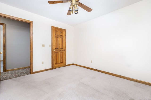 unfurnished bedroom with baseboards, light carpet, and a ceiling fan