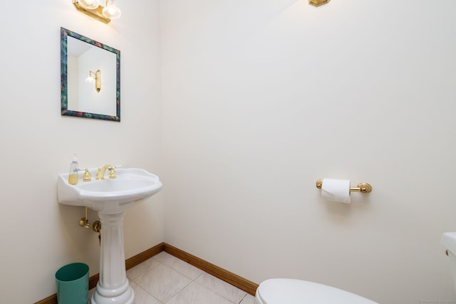 bathroom with tile patterned floors, toilet, and baseboards