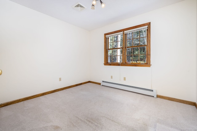 carpeted spare room with visible vents, a baseboard heating unit, and baseboards