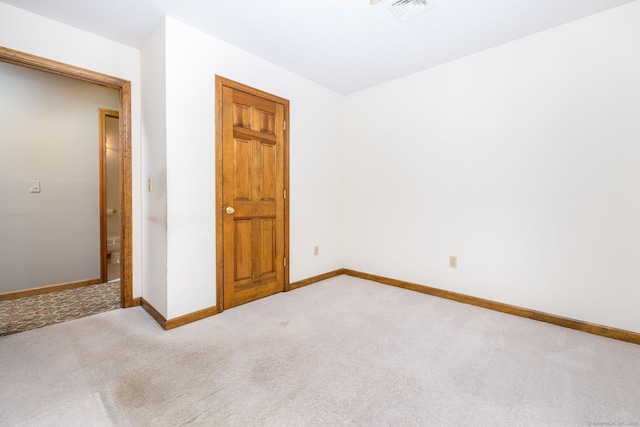 unfurnished bedroom with visible vents, baseboards, and light colored carpet