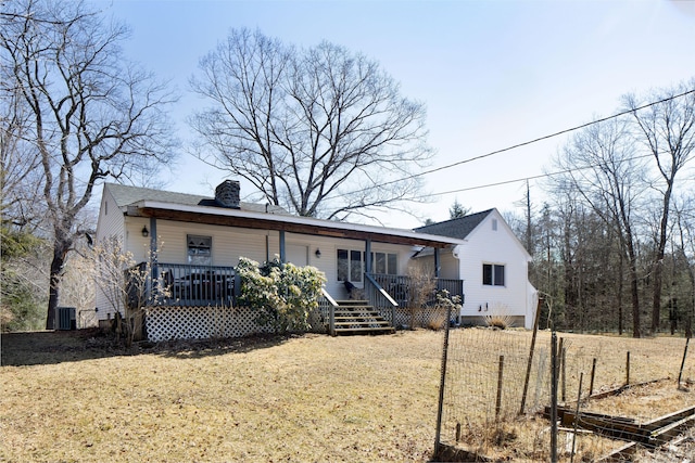 rear view of property with a lawn, a porch, and a chimney