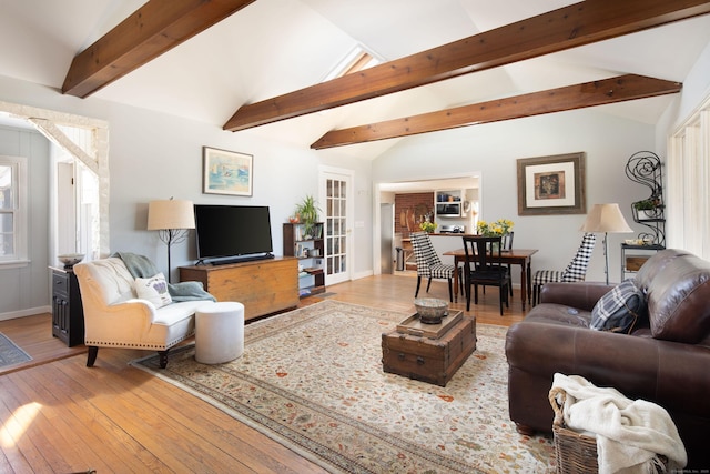 living room with lofted ceiling with beams, baseboards, and wood-type flooring