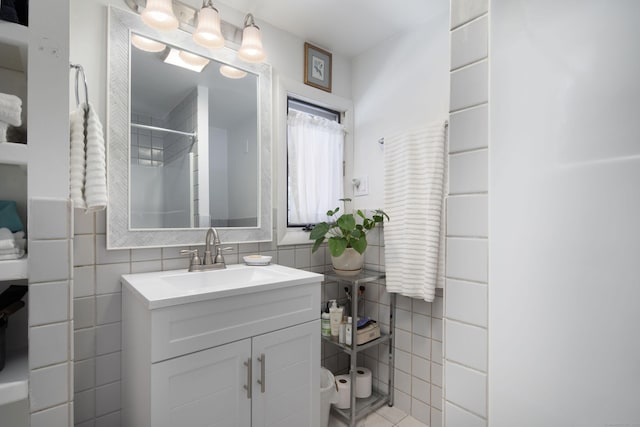 bathroom with a shower, tile walls, and vanity