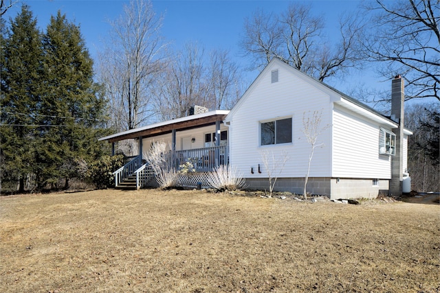 rear view of house featuring a porch and a chimney