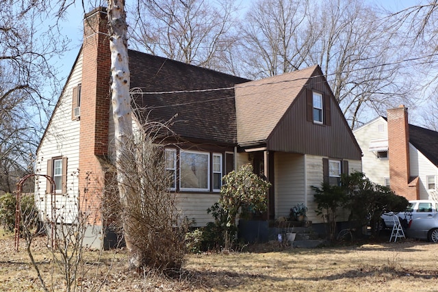 view of property exterior featuring a shingled roof and a chimney