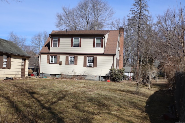 rear view of property featuring a lawn and a chimney