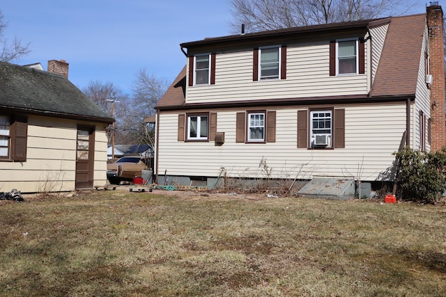 back of house featuring cooling unit, a lawn, and a chimney