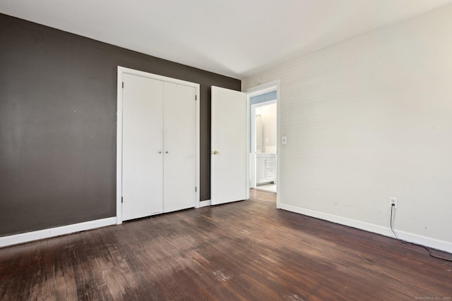 unfurnished bedroom featuring a closet, baseboards, and wood finished floors