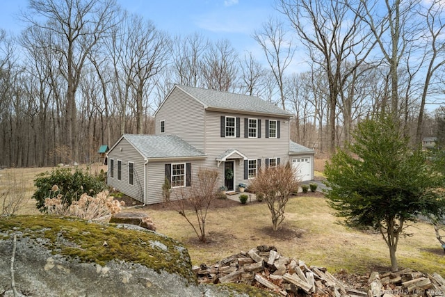 view of front of property featuring an attached garage and a shingled roof