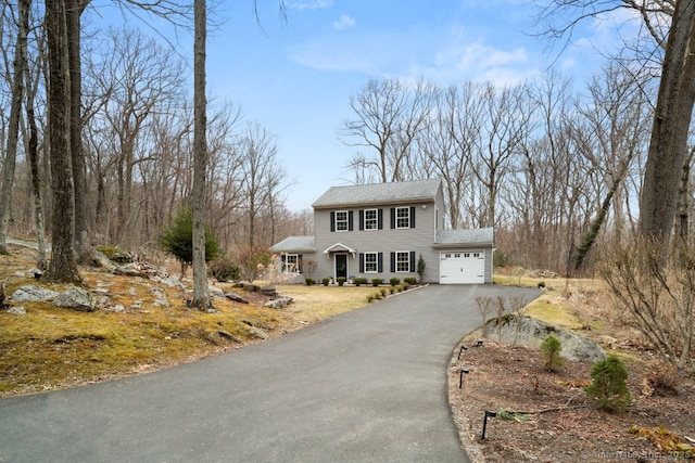 colonial inspired home with a garage and driveway