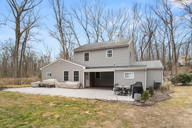 back of property with cooling unit, a patio, and a lawn