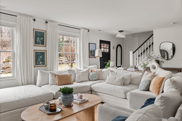 living area with stairway and ornamental molding