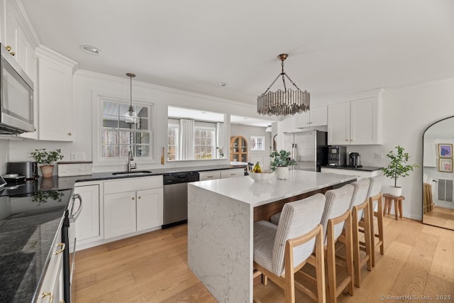 kitchen with a sink, white cabinets, and stainless steel appliances