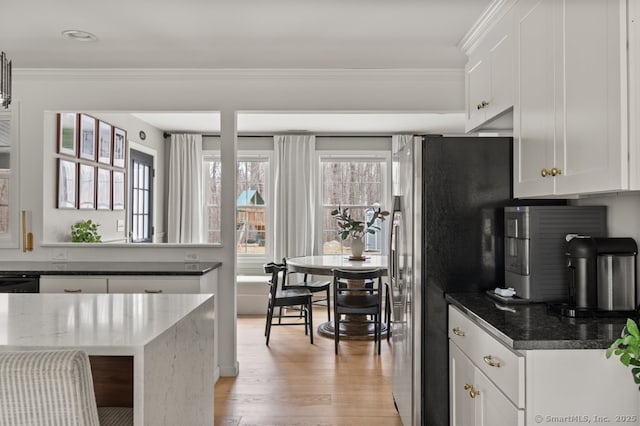 kitchen featuring white cabinetry, light wood-type flooring, freestanding refrigerator, and ornamental molding