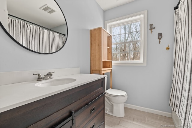 full bath featuring visible vents, toilet, wood finished floors, baseboards, and vanity