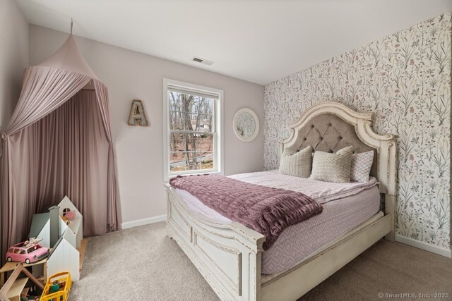 carpeted bedroom featuring visible vents, baseboards, and wallpapered walls