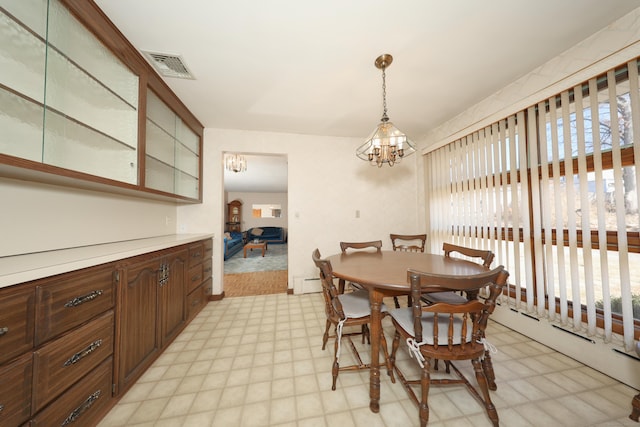 dining space featuring a notable chandelier, plenty of natural light, light floors, and visible vents