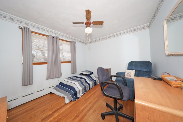 bedroom featuring a baseboard radiator, wood finished floors, and a ceiling fan