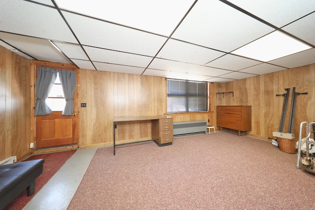 interior space featuring a drop ceiling, wood walls, and radiator