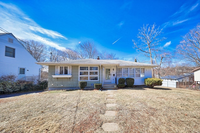 view of front of house with a front yard, fence, and a chimney