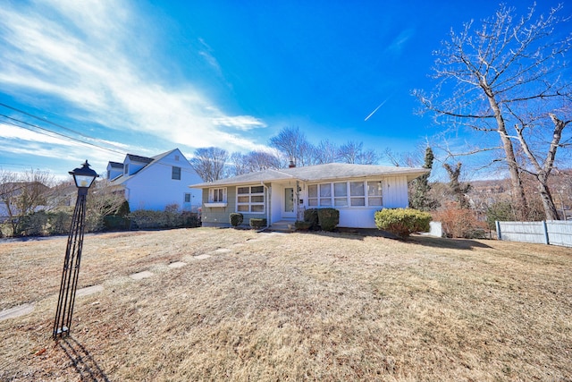 view of front of house with a front lawn and fence