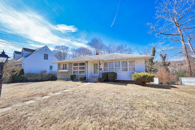 single story home with a front lawn and fence