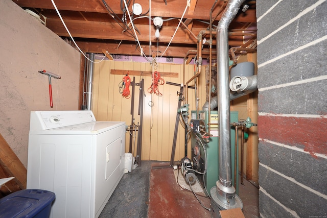 unfinished basement with a heating unit and washer / clothes dryer