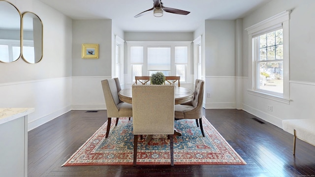 dining area featuring visible vents, baseboards, dark wood finished floors, and a ceiling fan