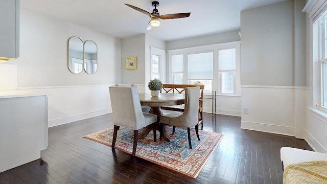 dining area featuring dark wood-type flooring, baseboards, and ceiling fan