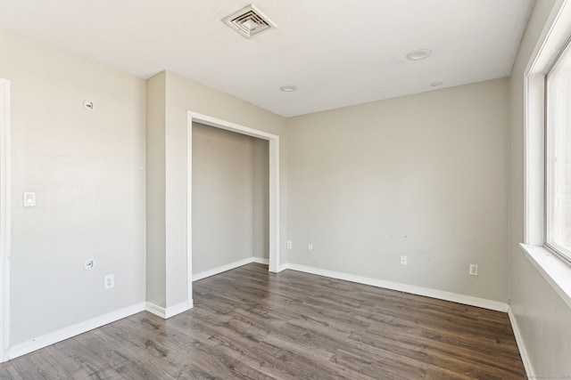 unfurnished bedroom with visible vents, baseboards, a closet, and wood finished floors