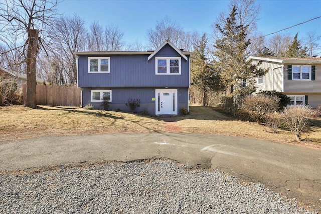 view of front facade featuring driveway and fence