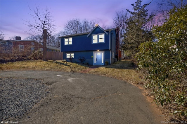 view of front facade featuring driveway and fence