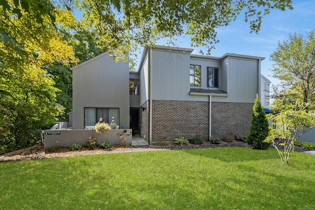 view of front of property featuring brick siding and a front lawn