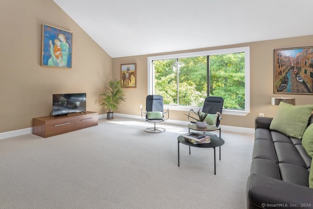 living area with high vaulted ceiling, baseboards, and carpet