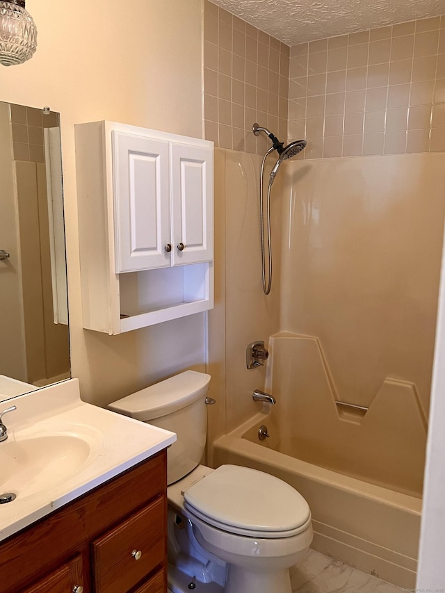 bathroom featuring vanity, a textured ceiling, bathing tub / shower combination, toilet, and marble finish floor