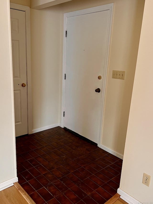 interior space featuring dark wood-type flooring and baseboards