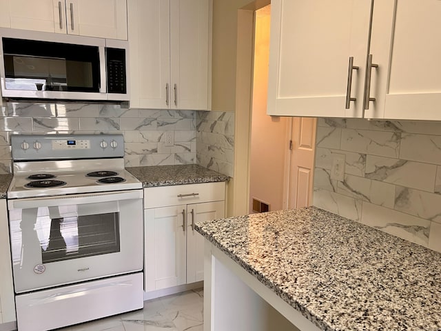 kitchen featuring white electric range oven, light stone countertops, white cabinetry, stainless steel microwave, and marble finish floor