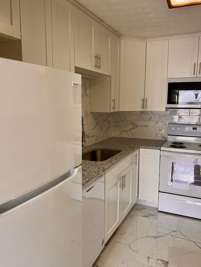 kitchen featuring marble finish floor, a sink, tasteful backsplash, a textured ceiling, and white appliances