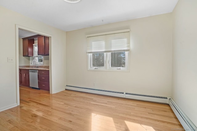 interior space featuring a sink, light wood-style floors, baseboards, and baseboard heating
