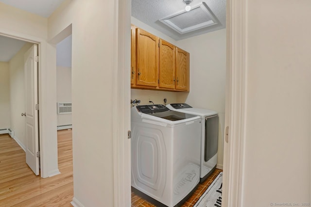 laundry room featuring washer and clothes dryer, cabinet space, light wood-style floors, a baseboard radiator, and attic access