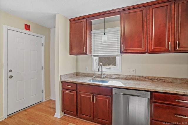 kitchen featuring light stone countertops, a sink, dark brown cabinets, light wood-style floors, and dishwasher