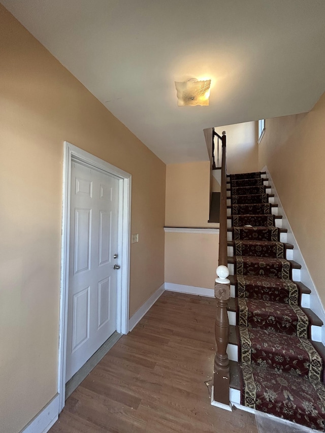 stairs featuring baseboards and wood finished floors