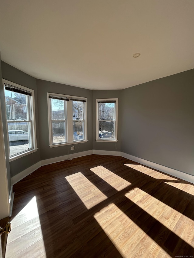 unfurnished room with wood finished floors and baseboards