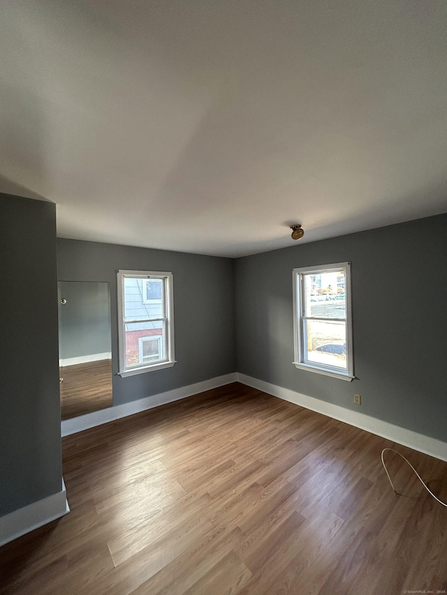 unfurnished room with wood finished floors and baseboards