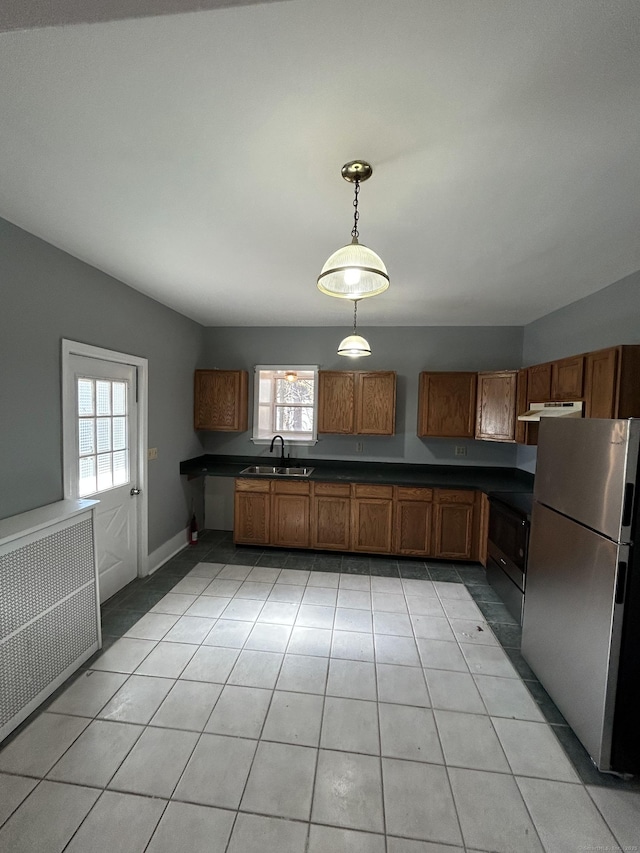 kitchen featuring a sink, under cabinet range hood, black electric range, freestanding refrigerator, and light tile patterned floors